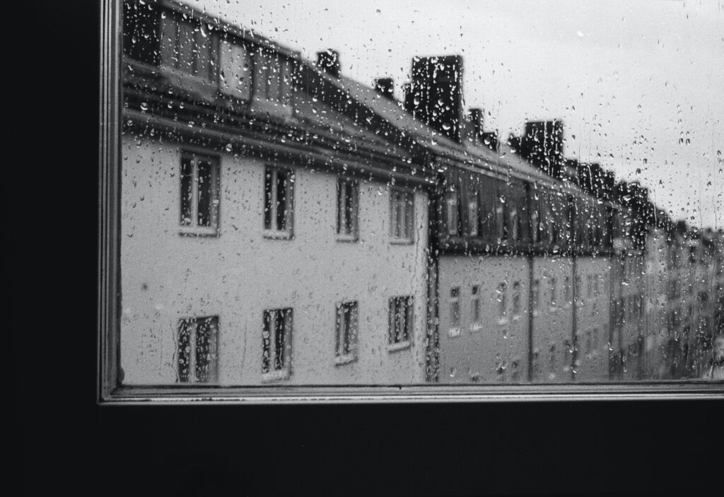 Una calle a través de un cristal con gotas de lluvia.