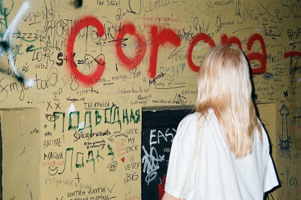 Una chica observa grafitis en una pared.